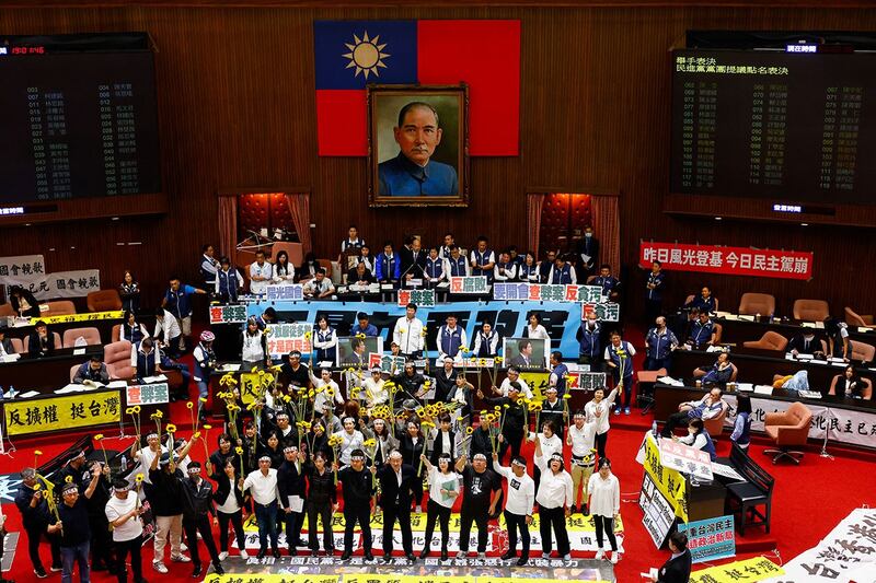 2024年5月21日,台湾的立法院漏夜审查《立法院职权行使法》修正草案,二读通过藐视国会罪、立法院调查权及听证权等多项条文。民进党立委在议场内手举向日葵高喊“反黑箱、反扩权”。(路透社)